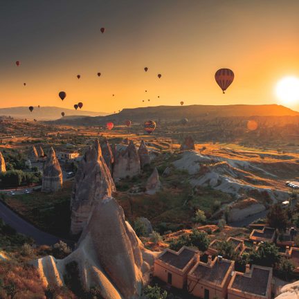 Luchtballonnen zweven boven de aardpiramides van cappadocië