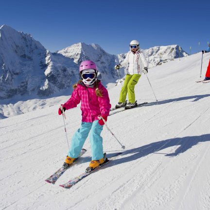 Familie aan het skiën van een skipiste