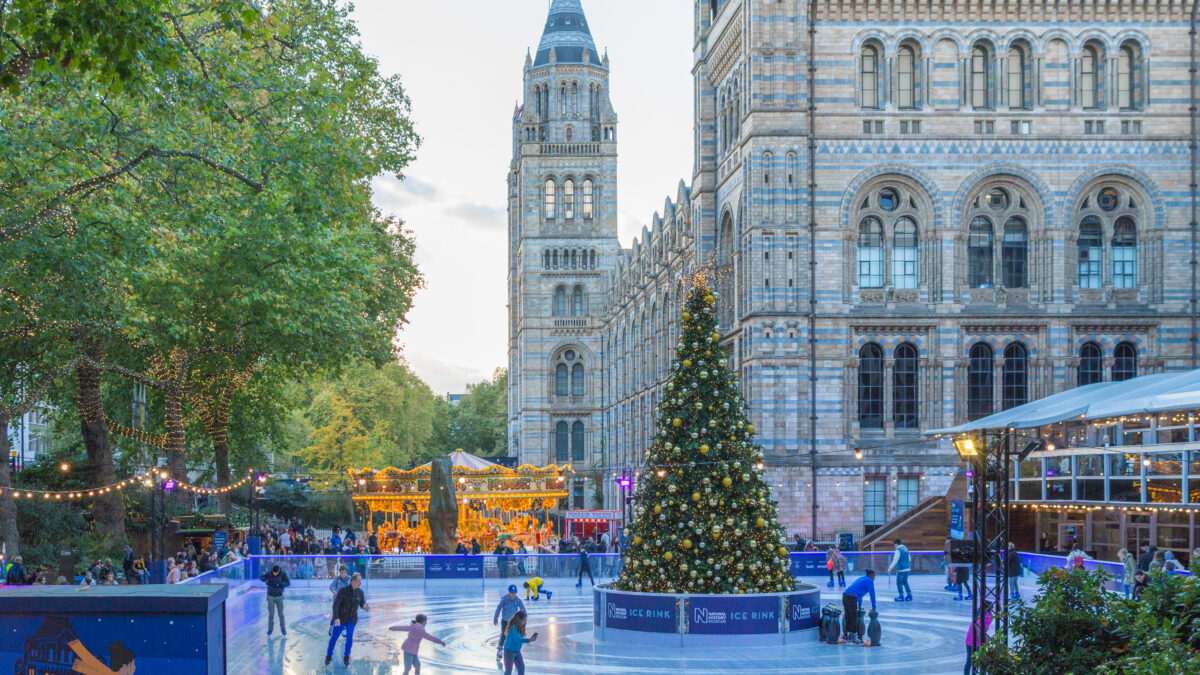 IJsbaan en kerstmarkt voor het Natural History Museum in Londen met uitzicht op de Big Ben