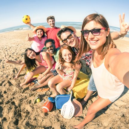 Vrolijke groep mensen op een strand maken een selfie
