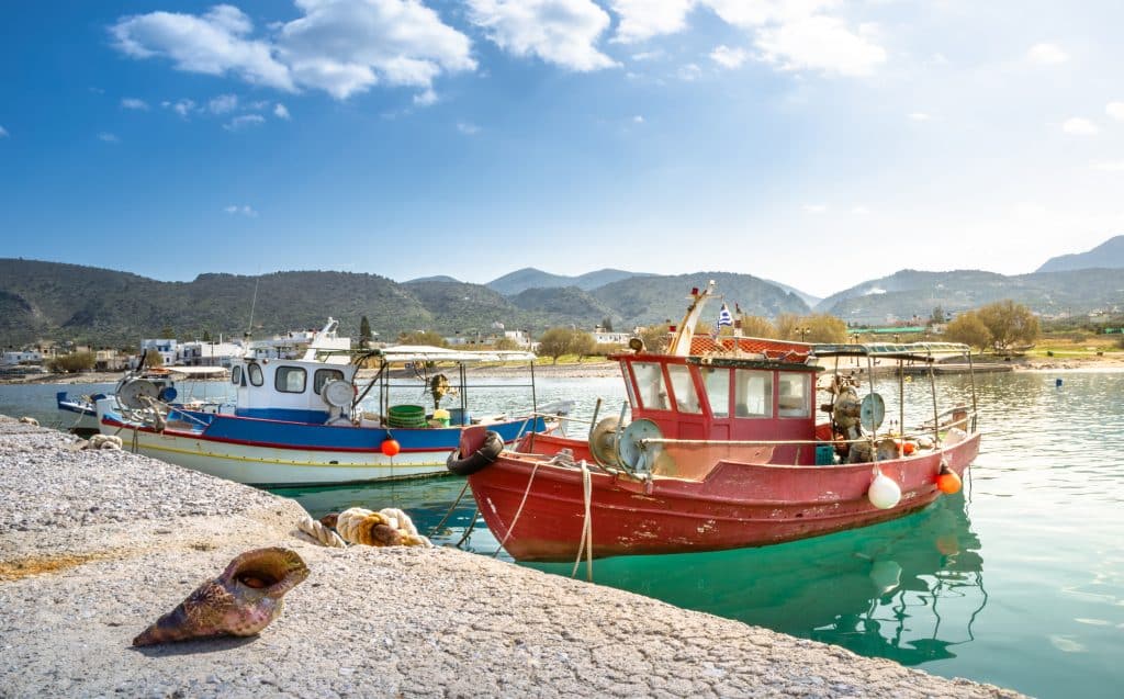 Traditionele vissersboten en schelpen in de haven van Milatos, Kreta, Griekenland