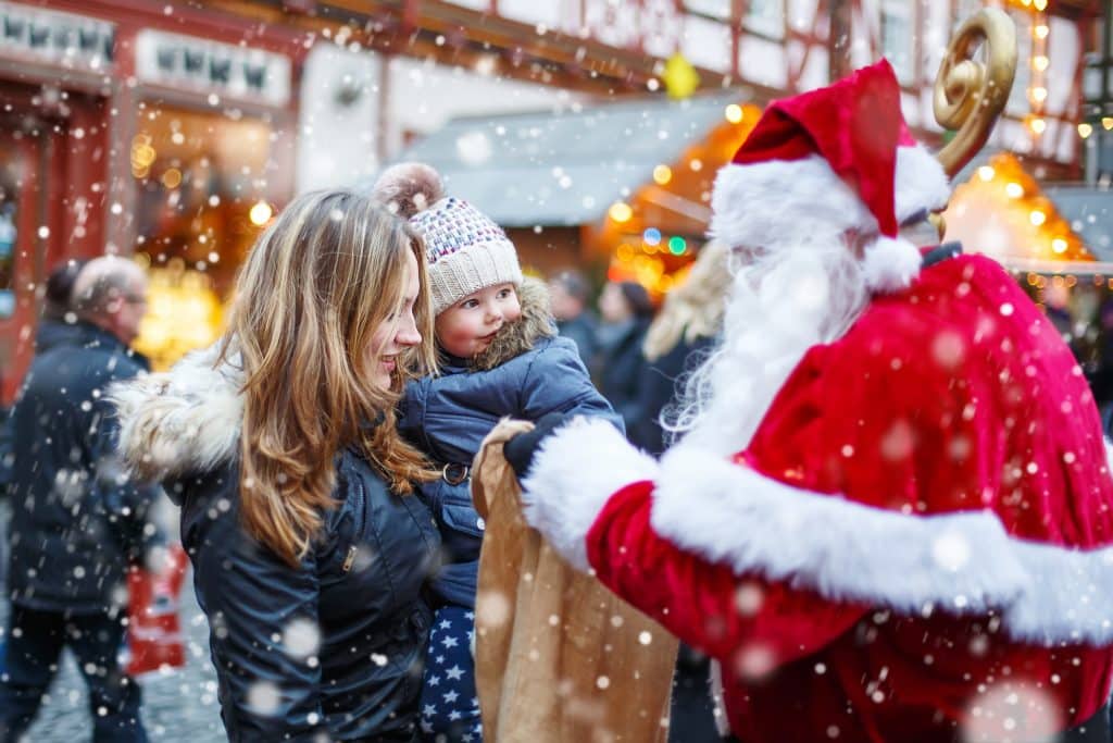 Schattig meisje met haar moeder en de kerstman op de kerstmarkt van munster in duitsland