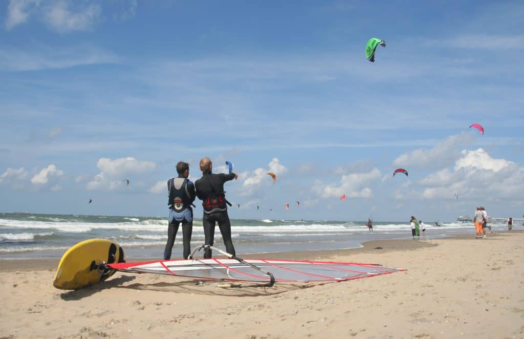 Surfers en vliegeraars op het strand in Nederland