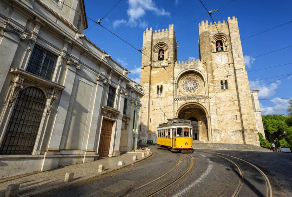 Tram rijdt voorbij de kathedraal Sé de Lisboa in Lissabon, Portugal