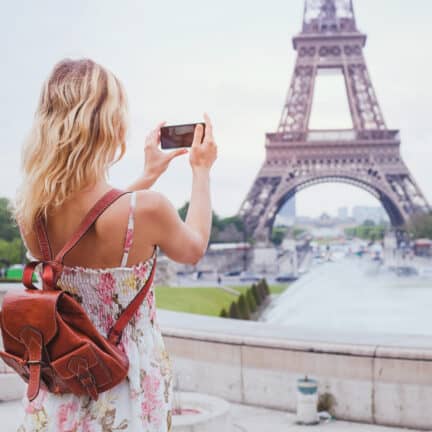Vrouwelijke toerist met rugzak neemt een foto van de Eiffeltoren in Parijs, Frankrijk