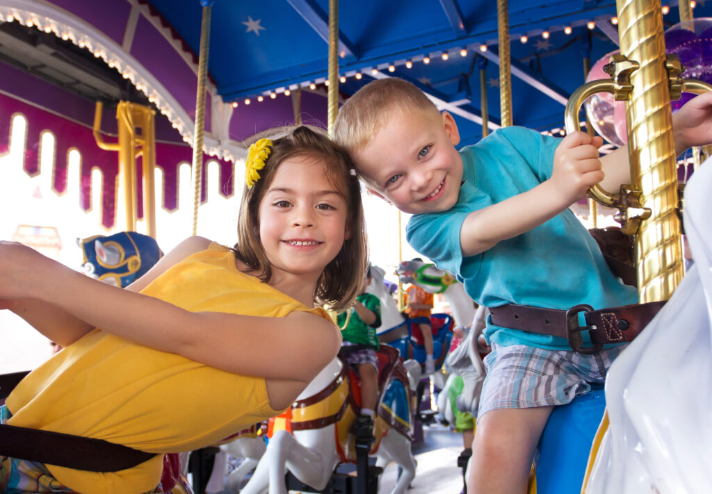 Kinderen hebben plezier in een draaimolen in Disney World, Orlando, Florida