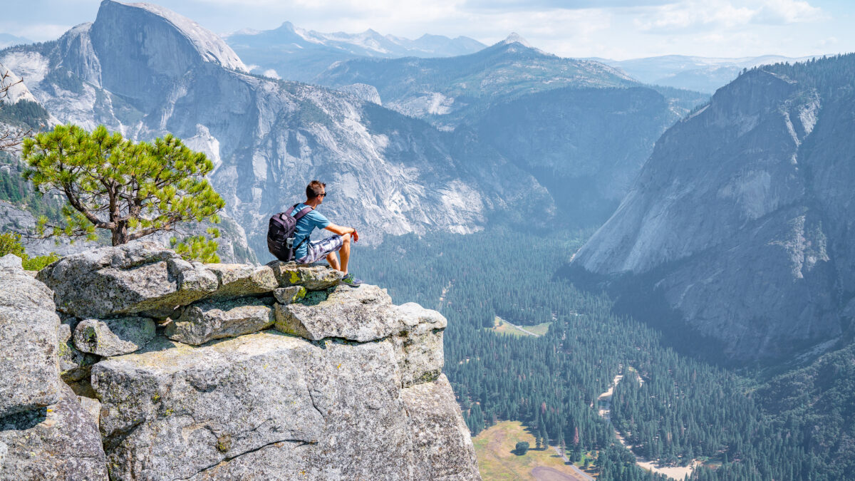 Man zit op de rand van de klif met uitzicht op El Capitan in Yosemite National Park