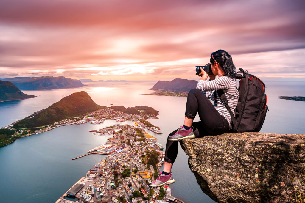 Vrouwelijke toerist maakt foto van de fjorden en Ålesund in Noorwegen