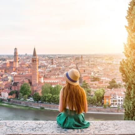 Jonge vrouw kijkt uit over de stad Verona in Italië