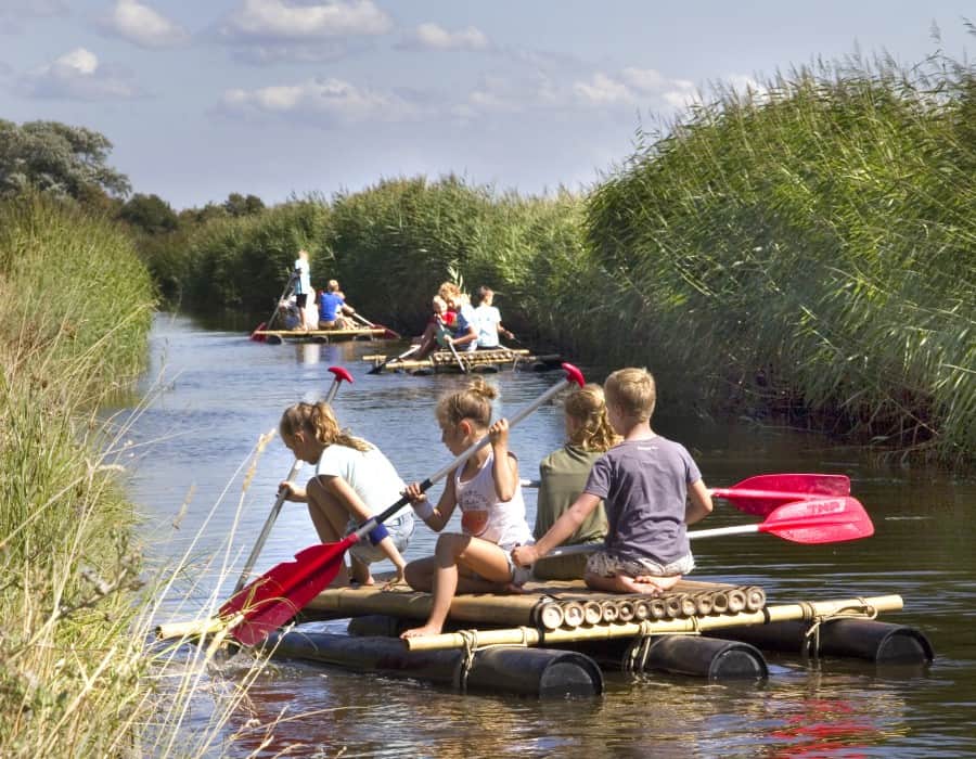 Kinderen aan het varen met een zelfgemaakt vlot