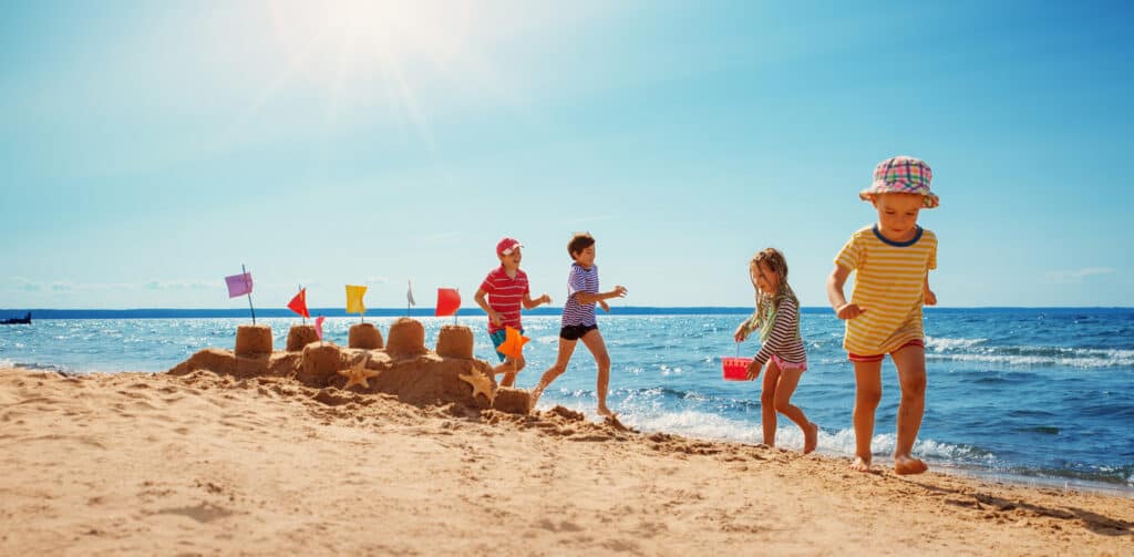 Kinderen bouwen een zandkasteel op het strand